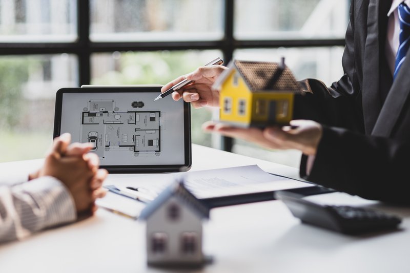 agente inmobiliario ofreciendo una casa a un nuevo cliente